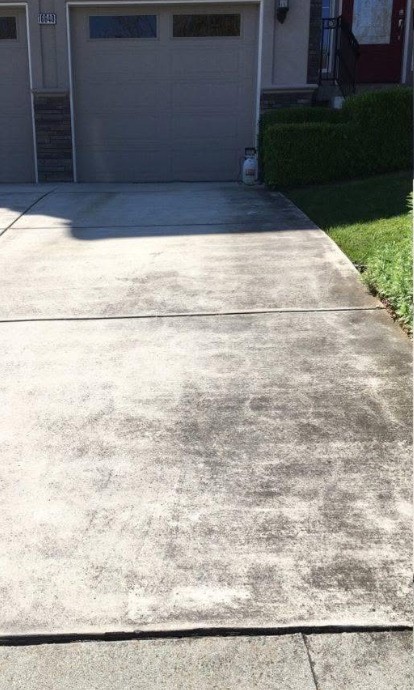 Driveway covered in dirt and organic staining before pressure washing